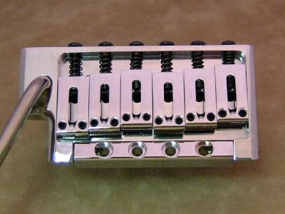 コマを取り囲むデザインはコマの横ブレを防ぐと同時に、演奏時ブリッジに置かれる右手のサポートにも役立っている。また、トラディショナルなトレモロから無改造で交換が可能。